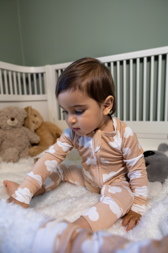 Baby investigating a blanket while wearing a Kibby bamboo pyjamas