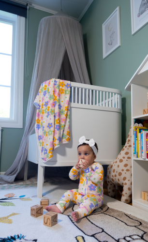 Baby wearing Daisy Kibby bamboo pyjamas with blanket in the background