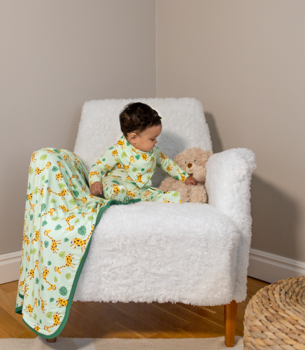 Safari Toddler playing with a teddy bear next to her Safari blanket